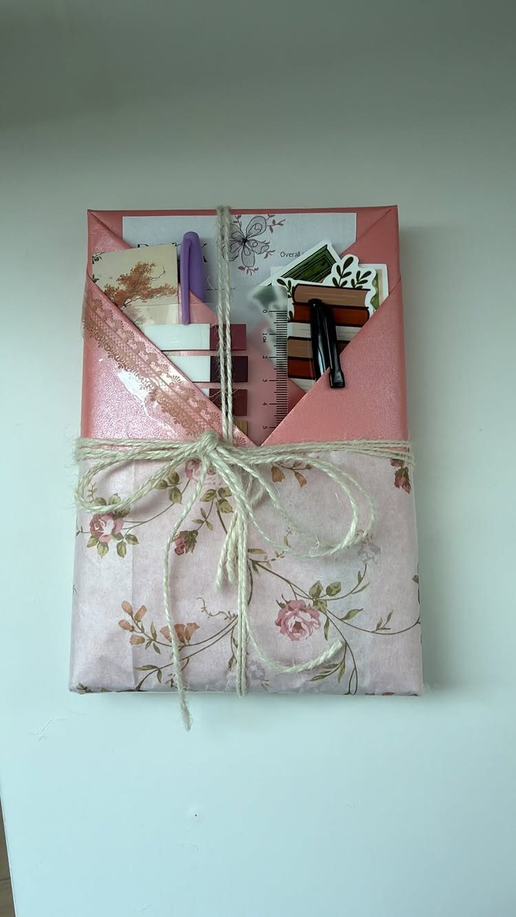 Floral wrapped gift package containing a purple pen and various reading bookmarks.