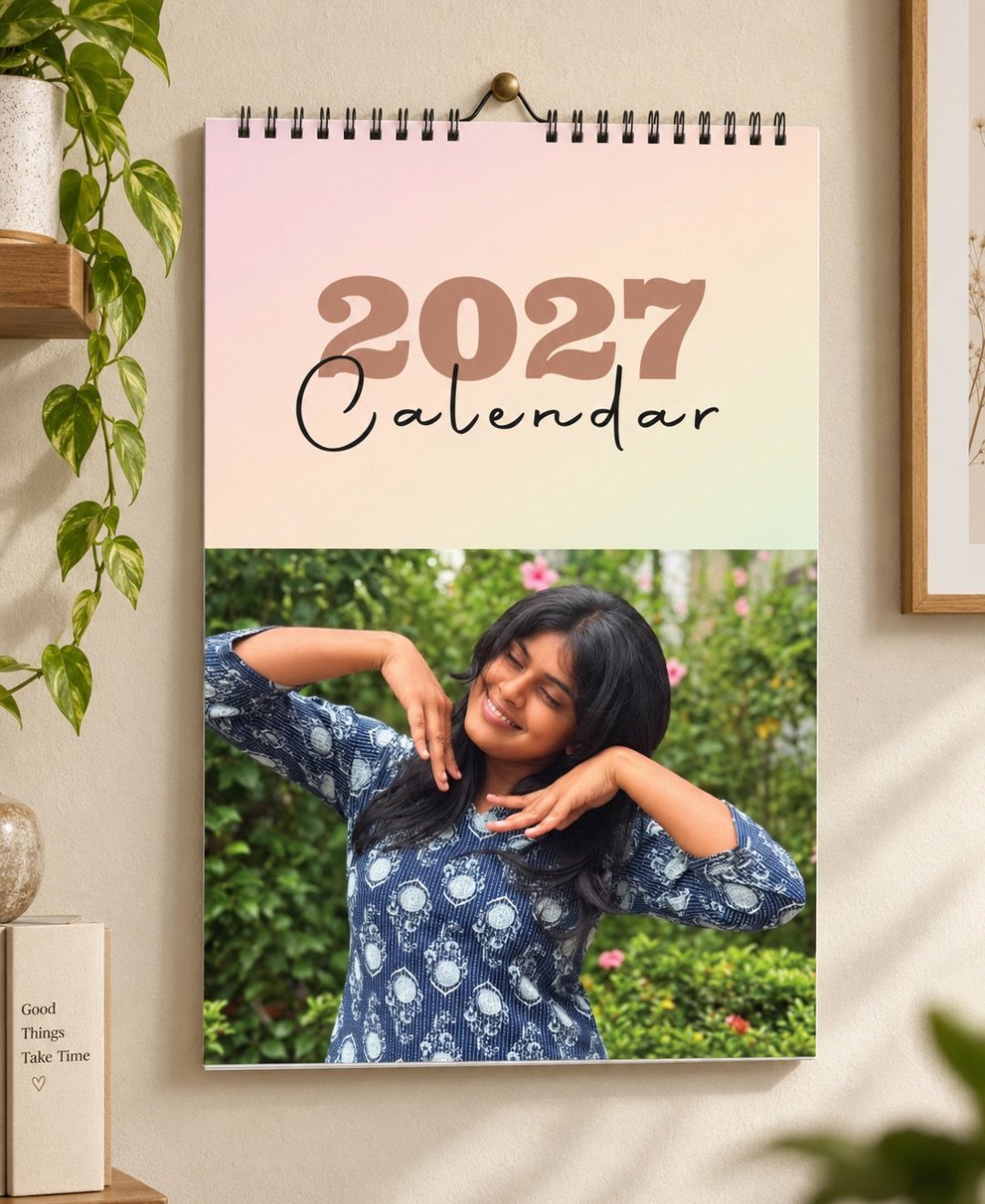 Spiral-bound 2027 wall calendar featuring a photo of a smiling woman outdoors.