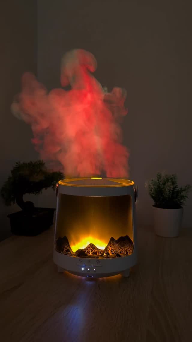 White humidifier emitting red mist with a glowing flame effect on wooden table