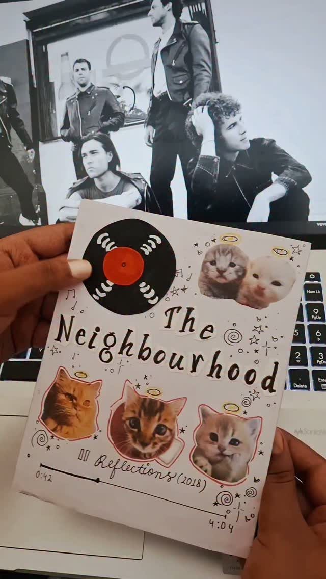 Handmade card with kitten photos and music theme held in front of laptop