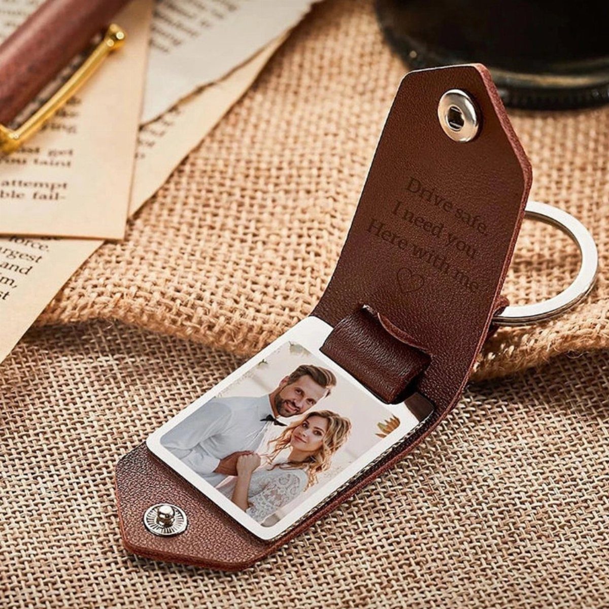Brown leather folding keychain with an engraved message and a couple's photo inside.