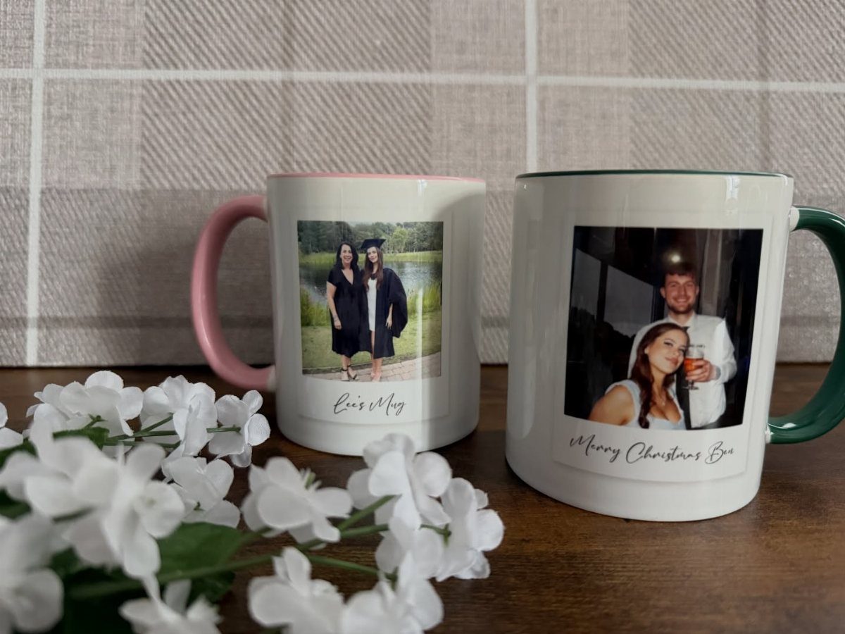 Two personalized white mugs with photos of couples and text on a wooden table.