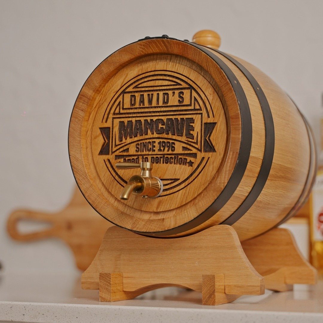Small wooden whiskey barrel with personalized engraving on a wooden stand
