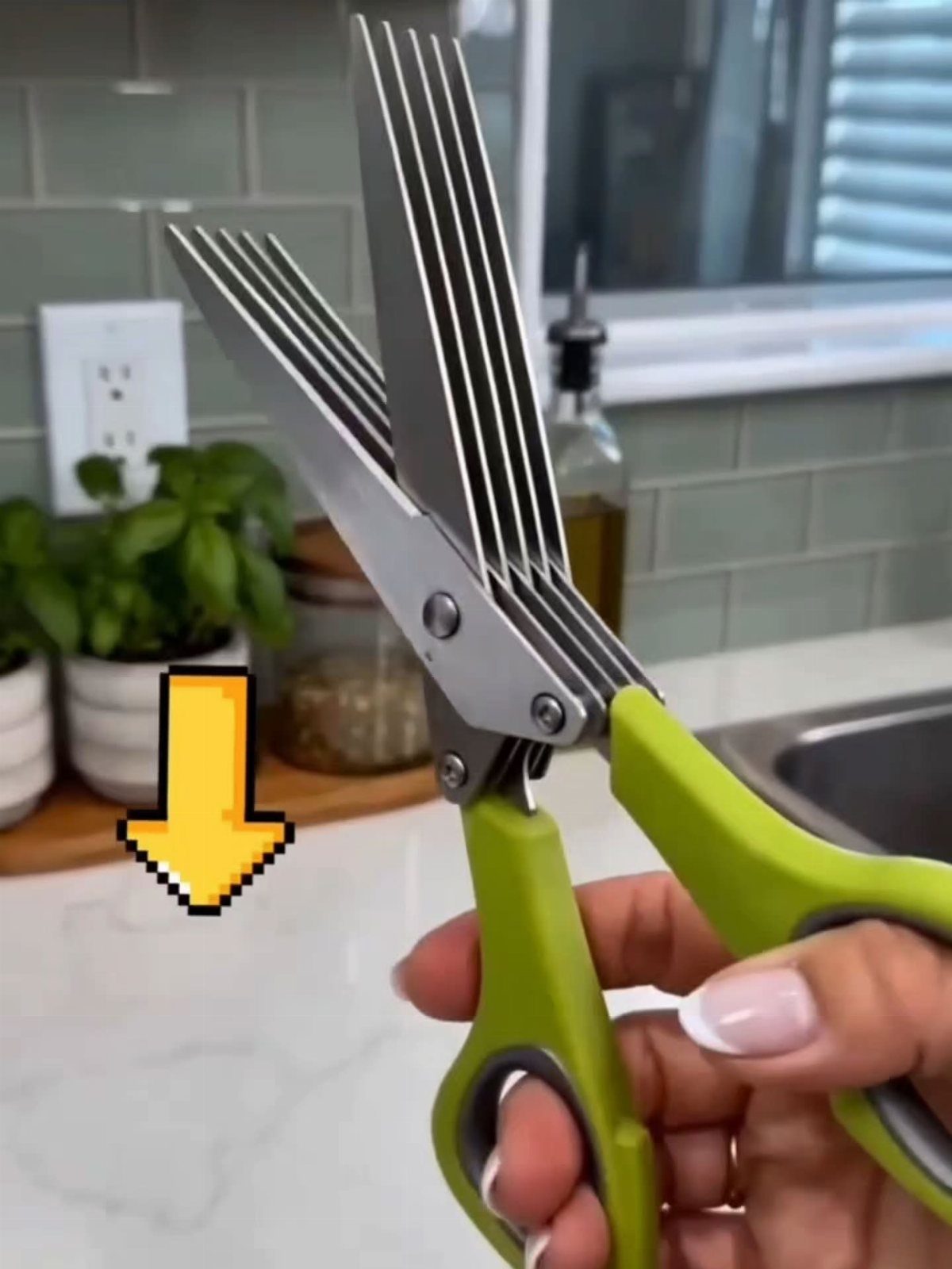 Multi-blade herb scissors with lime green handles held in a bright kitchen.