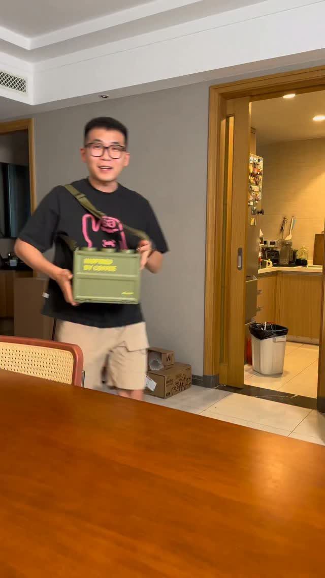 Man holding an olive green BrewSpoon portable coffee infuser in a room.