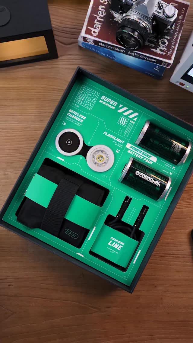 Green and black electronics gift set in a box on a wooden table