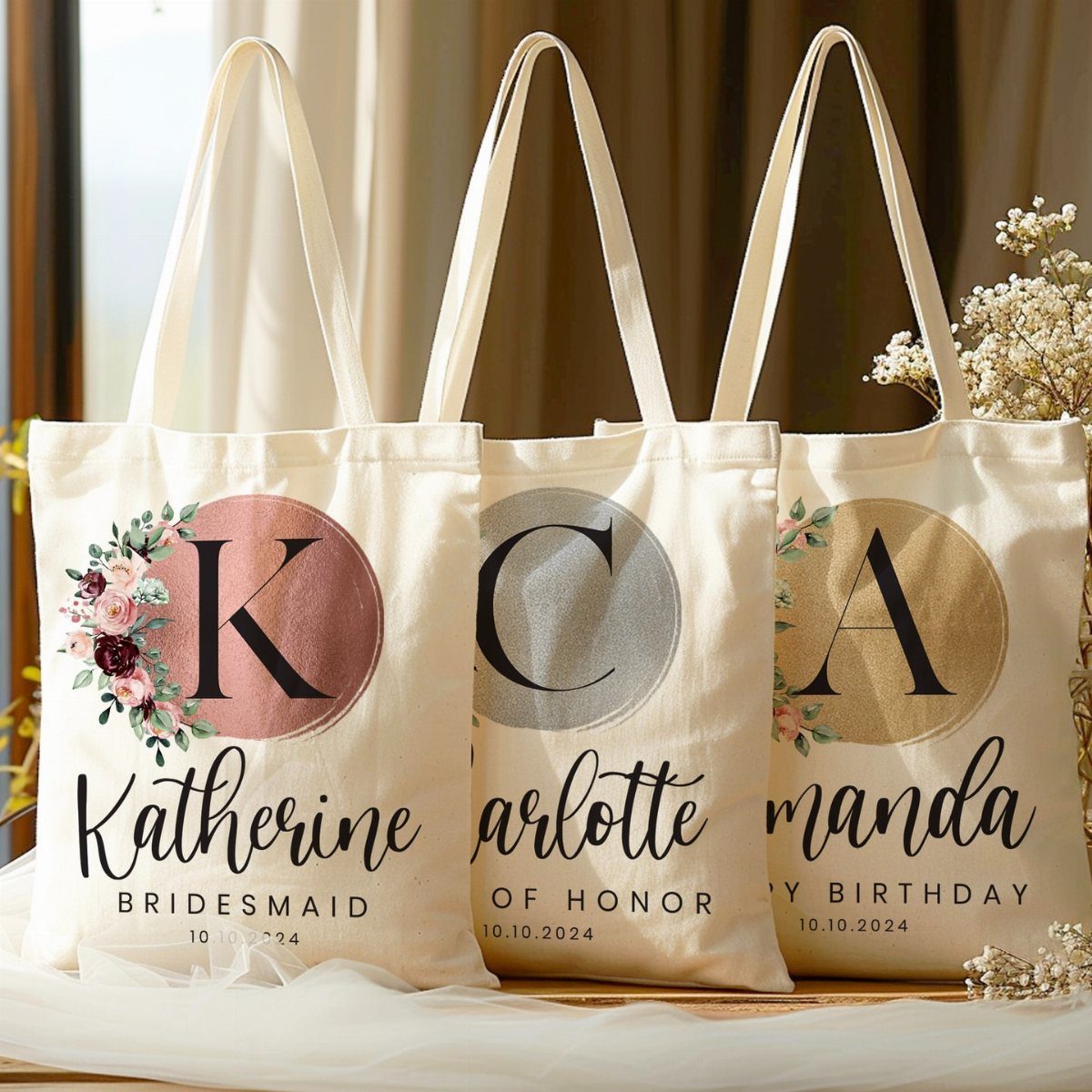 Three personalized canvas tote bags with floral monograms and names for wedding party.