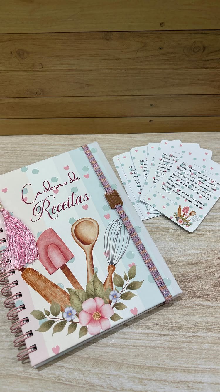 Recipe notebook with floral cover and matching handwritten recipe cards on wooden surface