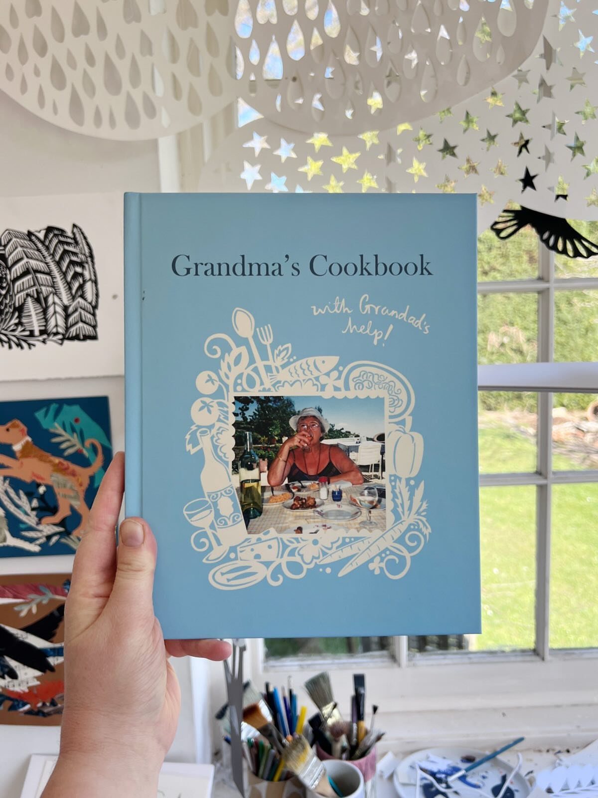 Light blue custom cookbook titled Grandma's Cookbook featuring a photo of an elderly woman.