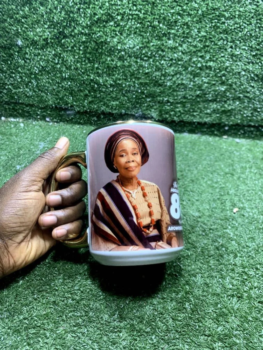 Custom photo mug featuring an elderly woman held against green grass background