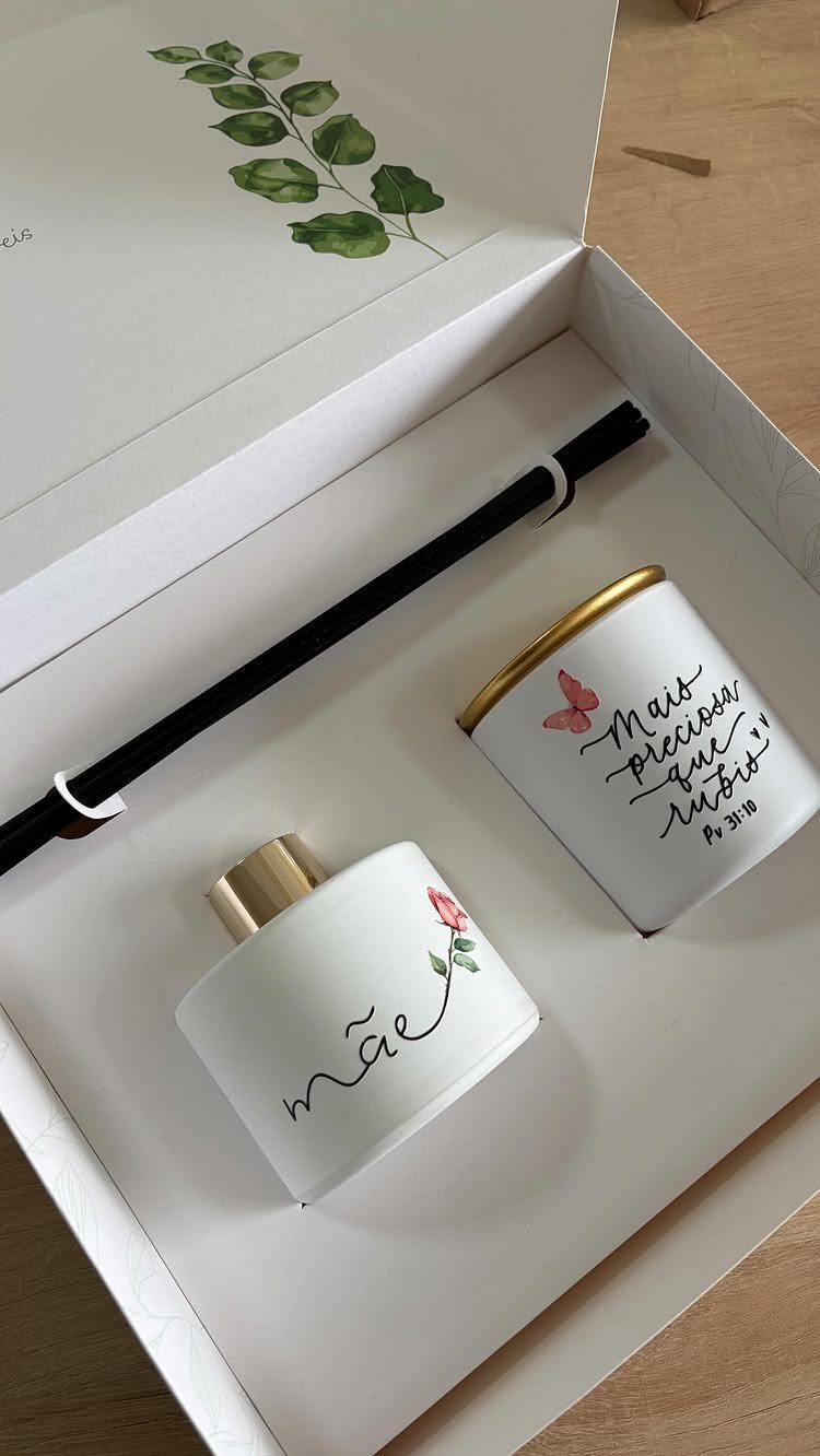 Two white ceramic cups with gold lids in a white gift box.