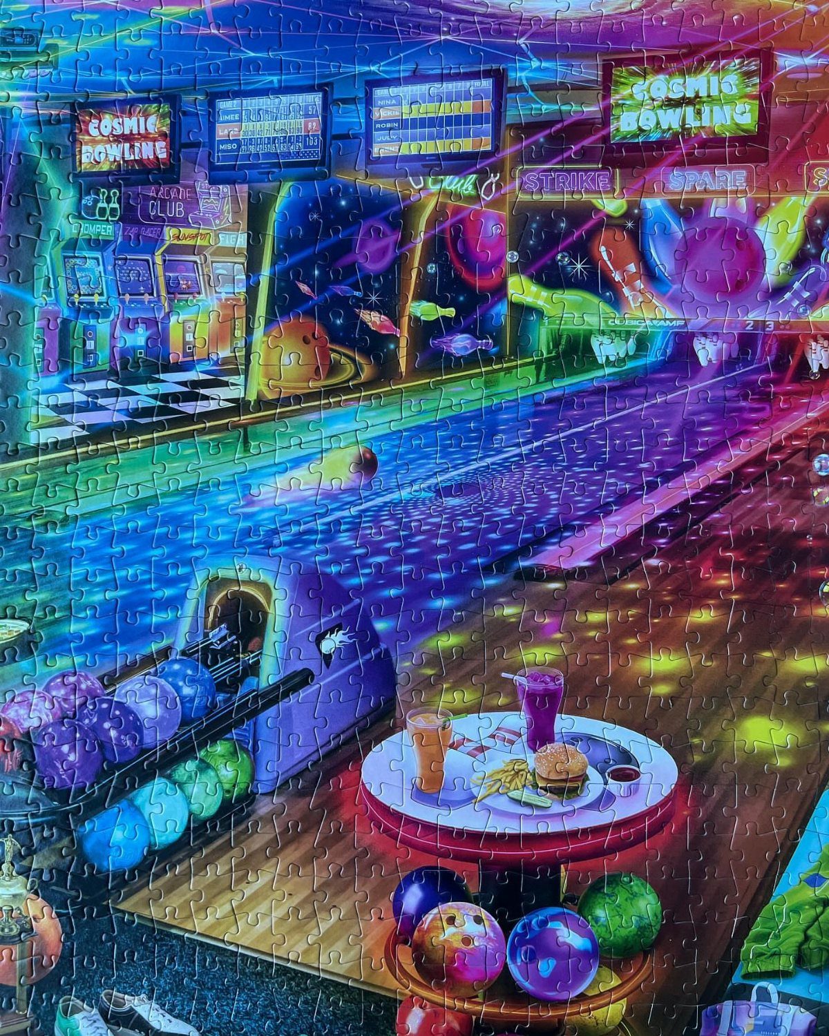 Completed jigsaw puzzle of a neon cosmic bowling alley with colorful bowling balls.