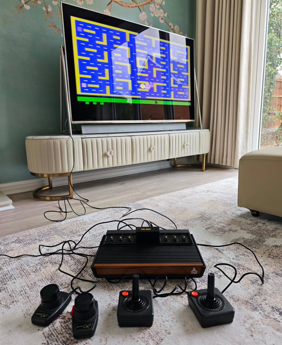 Vintage Atari 2600 console and controllers connected to a TV playing a retro game