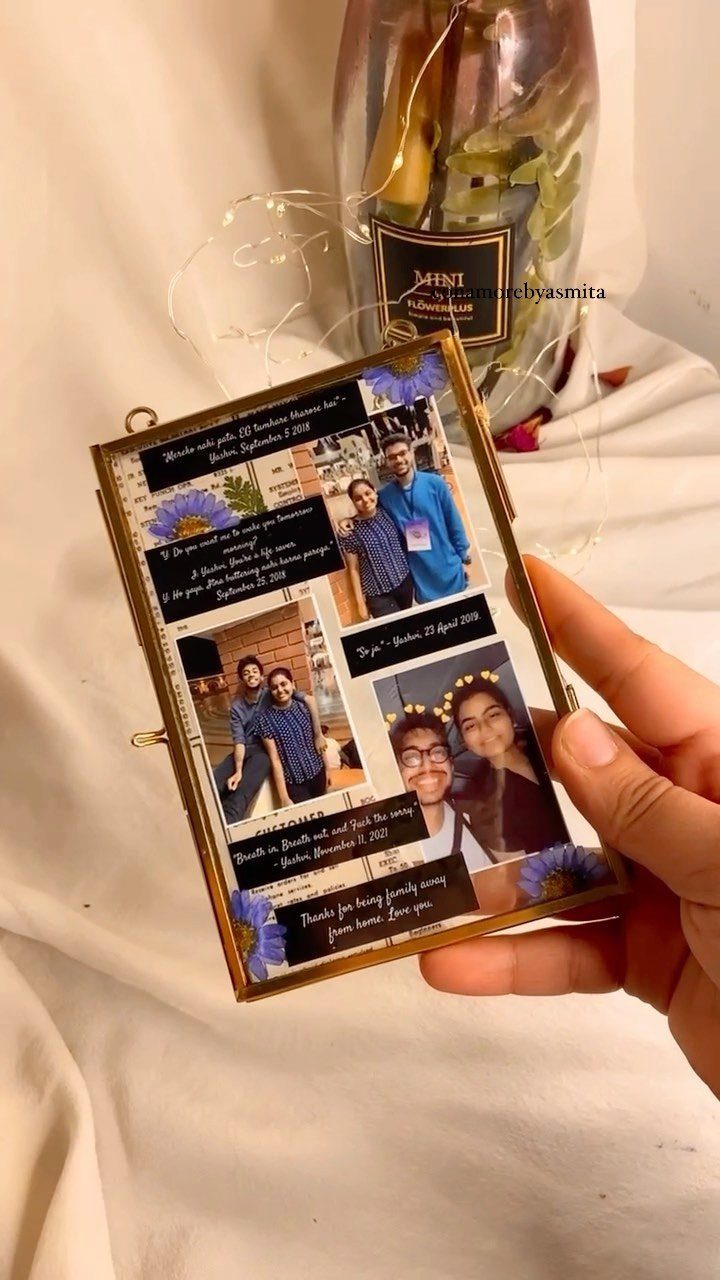 Hand holding a gold-framed photo collage with pictures of two men and notes.