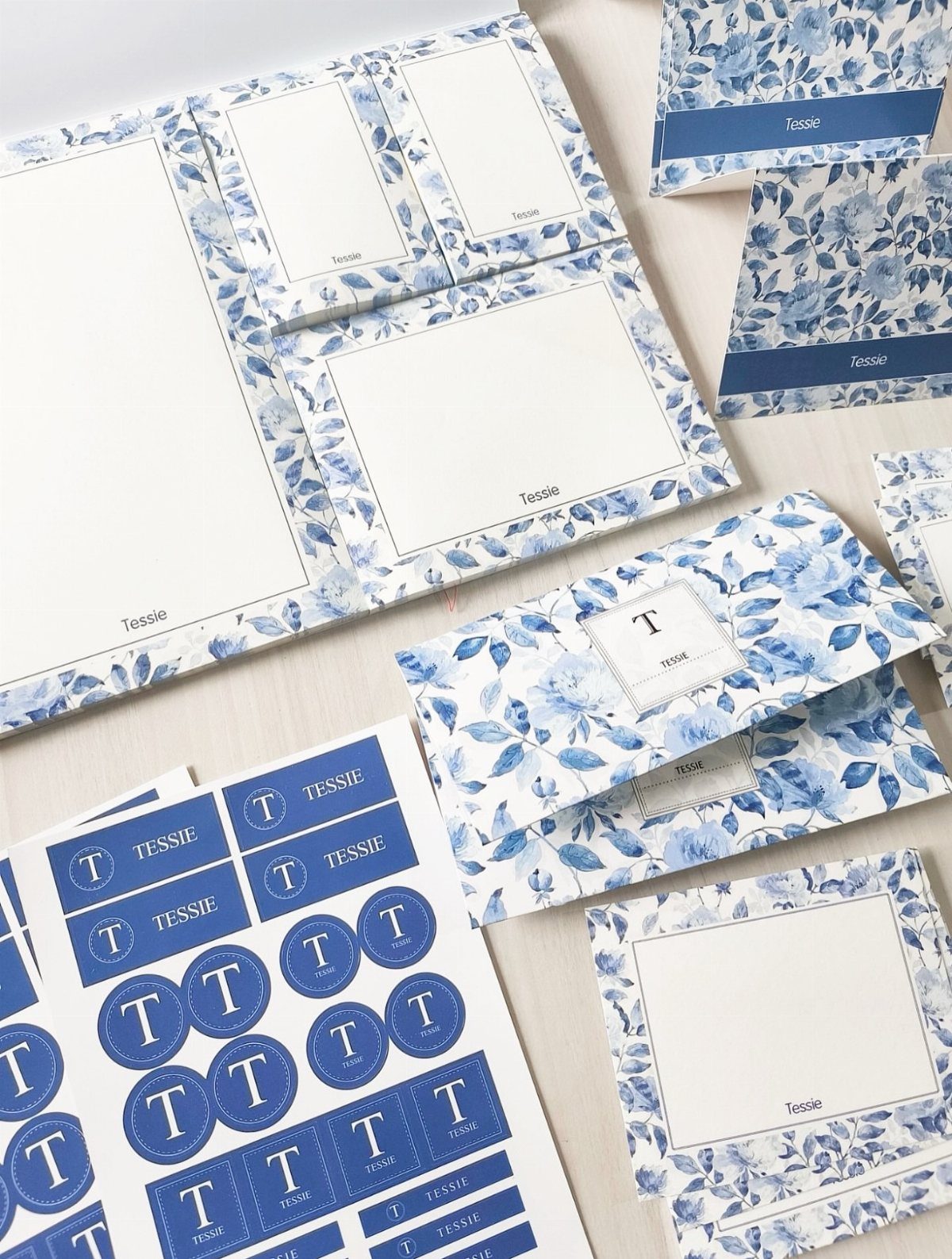 Personalized notepads and stationery with blue floral patterns and the name Tessie.