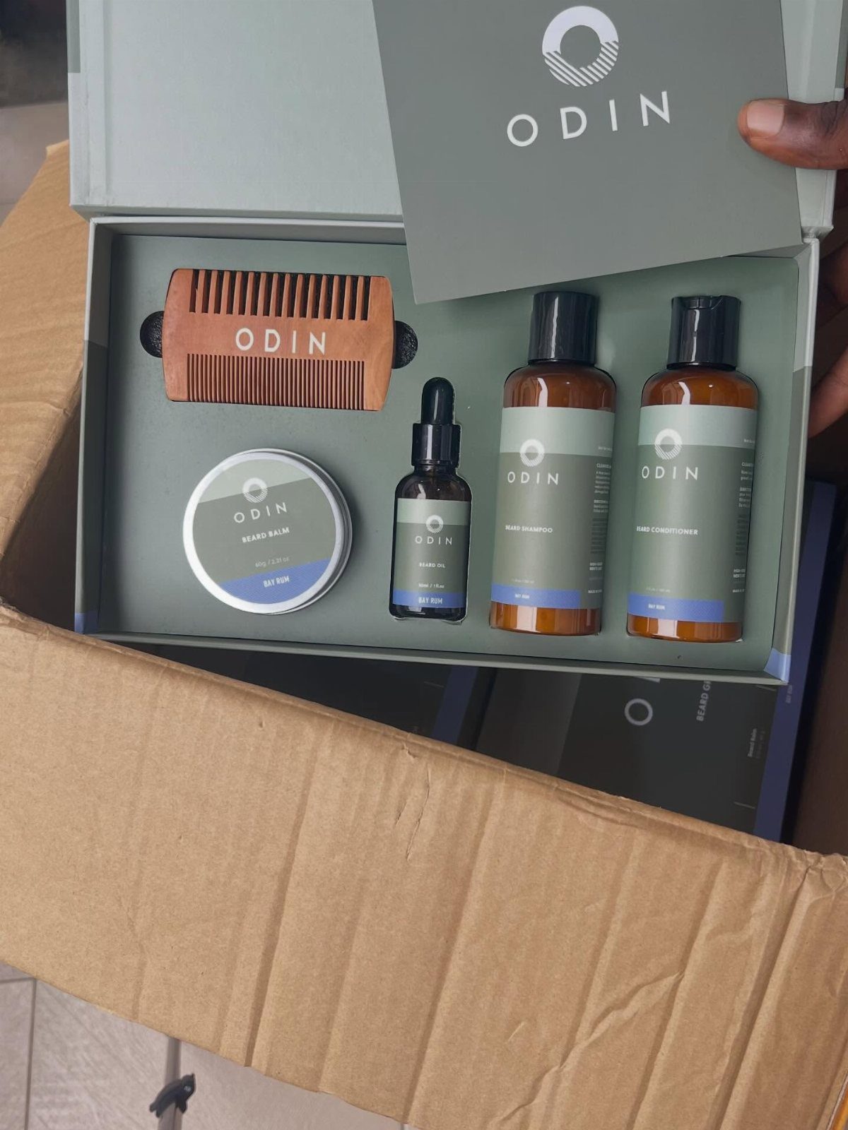 Men's grooming gift set with wooden comb and skincare bottles in a box