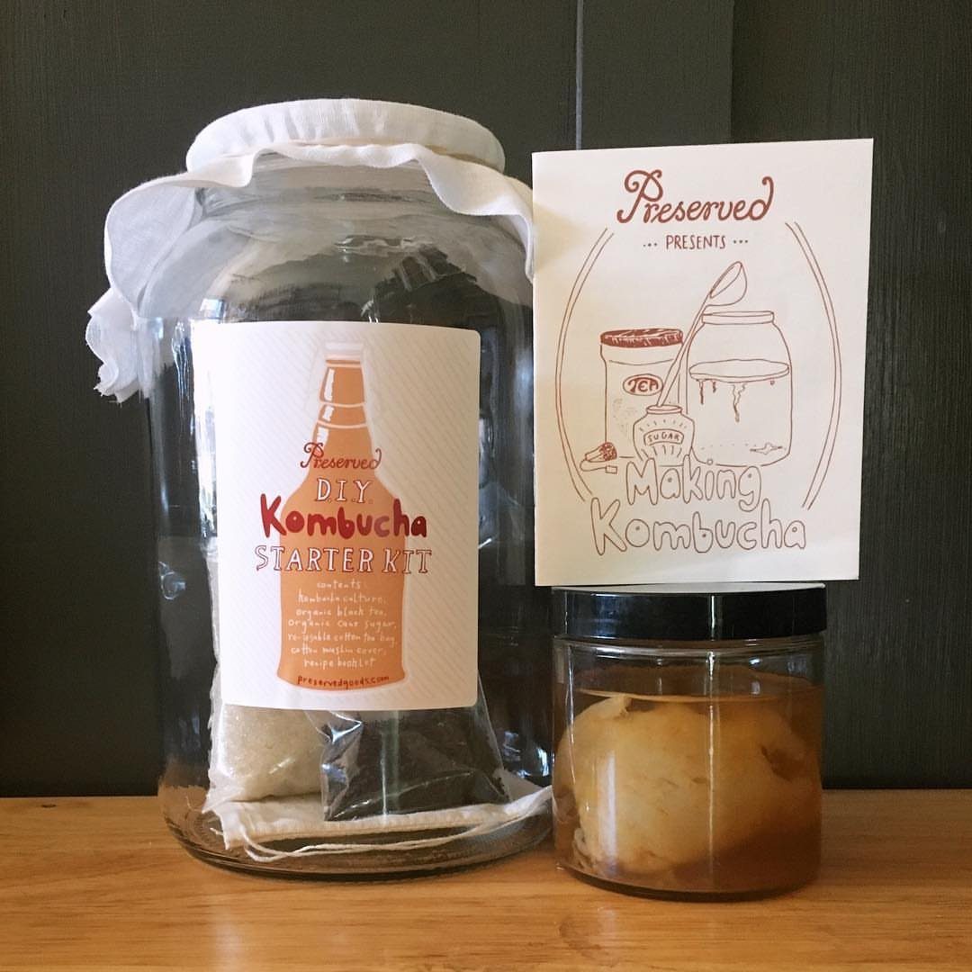DIY Kombucha Starter Kit with glass jars and instructions on a wooden table.