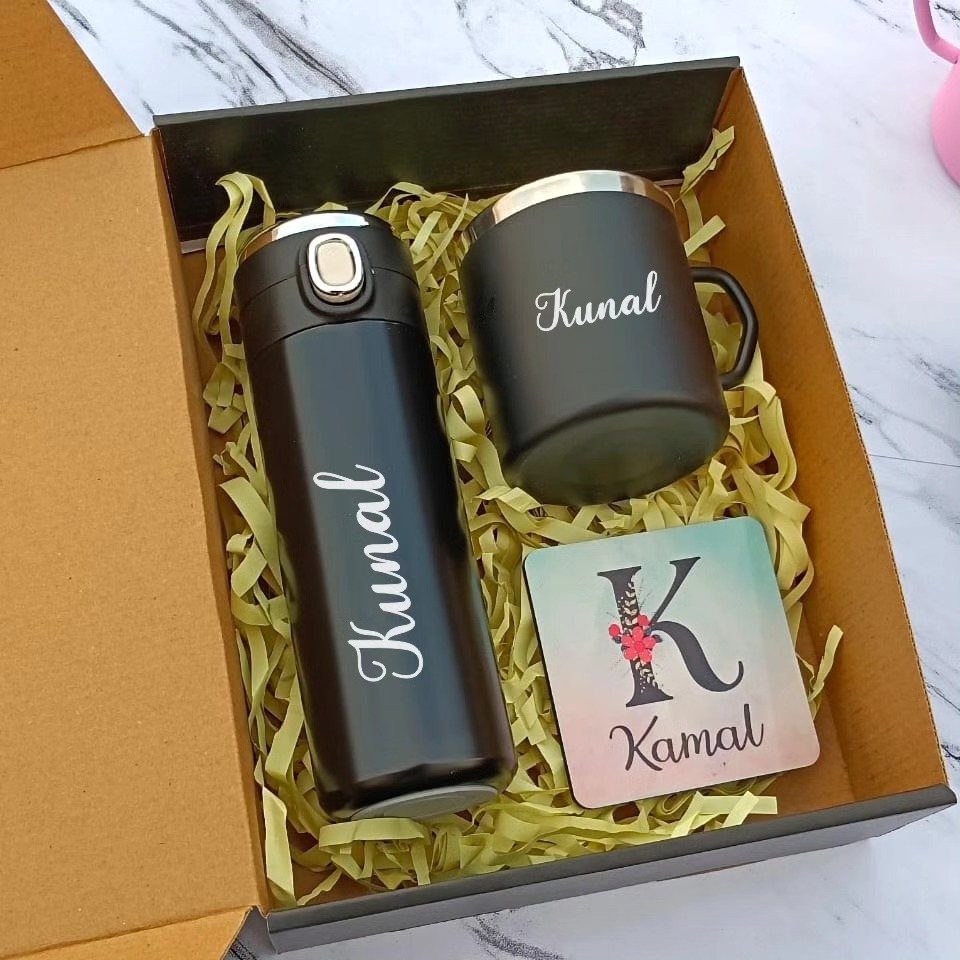 Personalized black water bottle and mug set in a gift box with yellow filler.