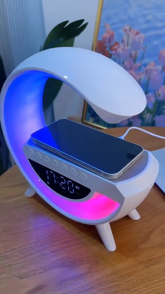 White curved desk lamp with digital clock and smartphone on wireless charging base