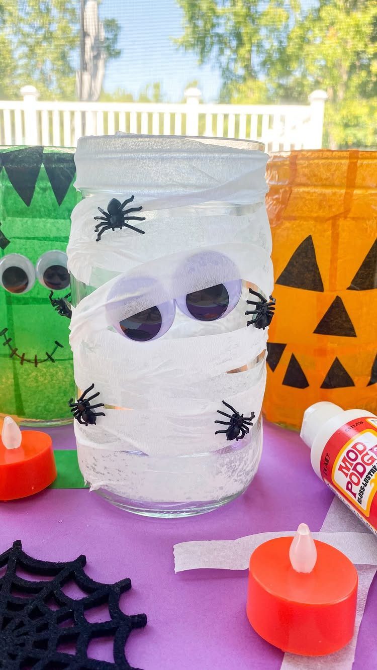 Halloween decorated mason jars featuring a mummy, pumpkin, and monster on purple background