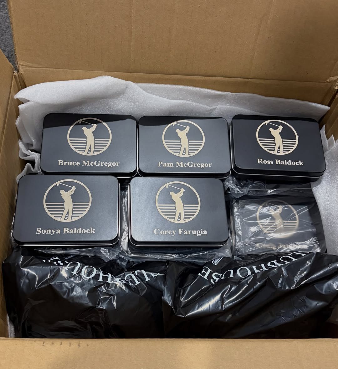 Personalized black metal tins with gold golf logos and names in a box