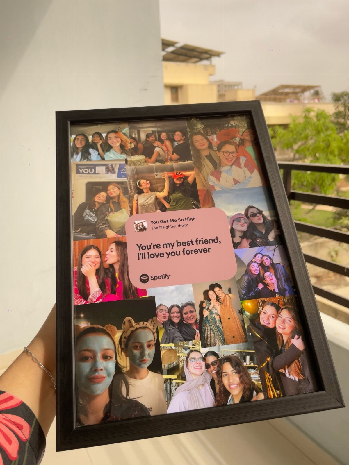 Black photo frame containing a collage of friends and a pink music graphic.