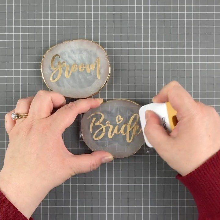 Hands crafting agate coasters with gold Bride and Groom lettering on grid mat