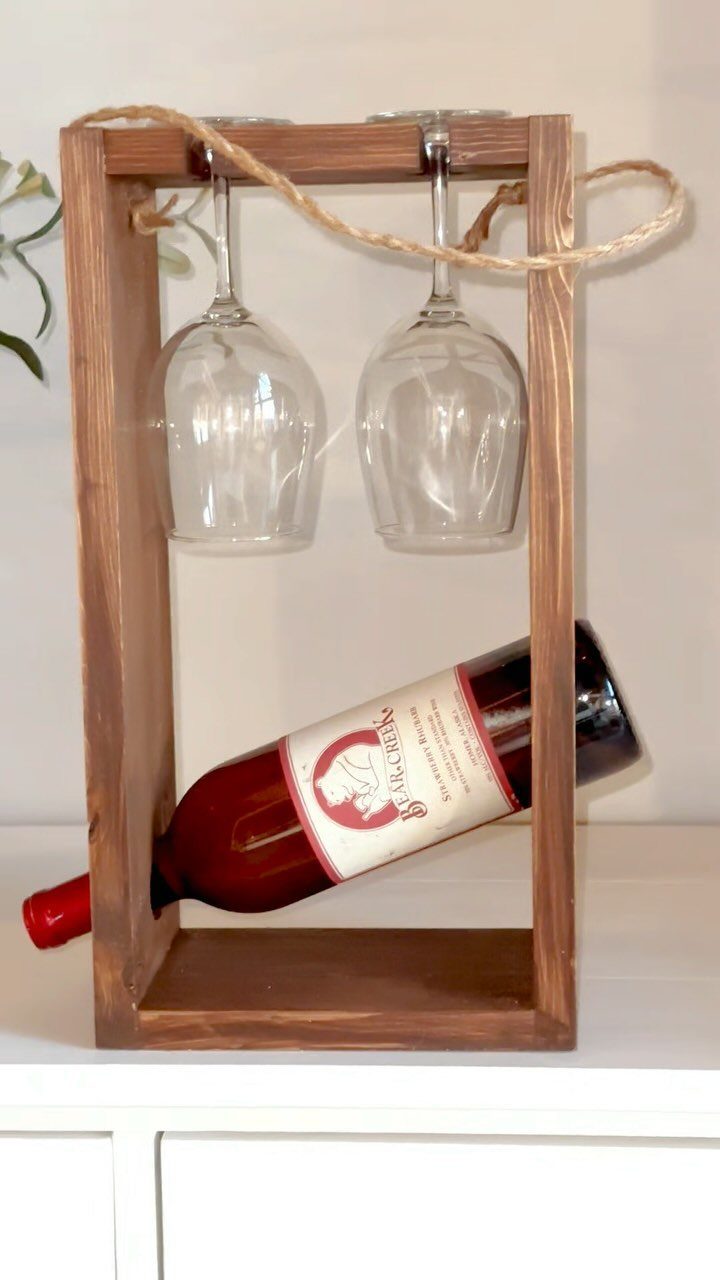 Wooden wine carrier with a bottle of red wine and two wine glasses