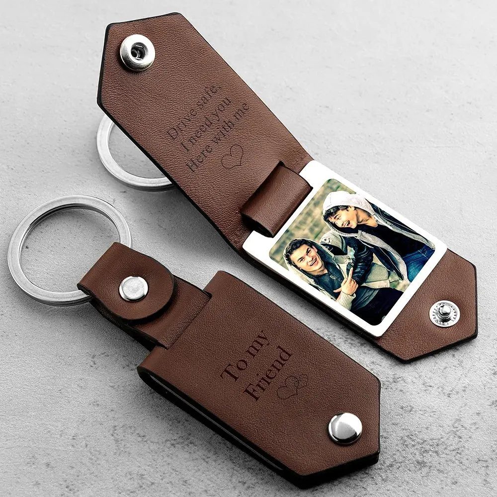 Two brown leather keychains, one open showing a photo of a couple.