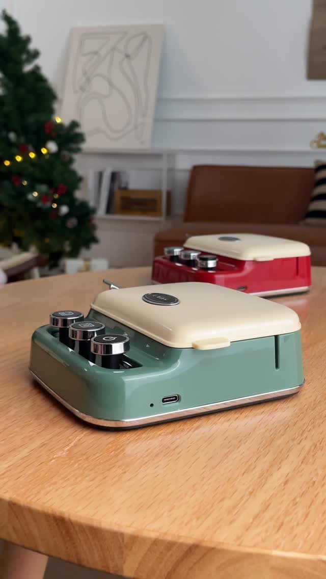 Two retro sandwich makers in green and red on a wooden table near Christmas tree