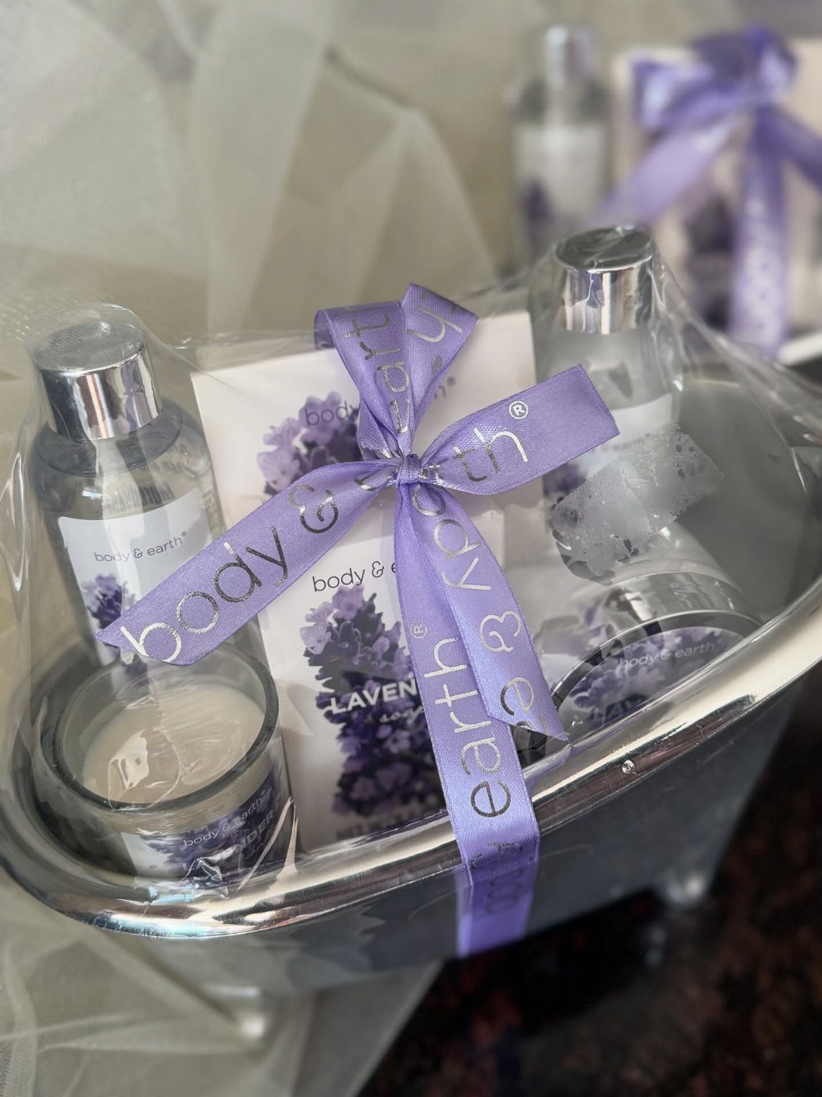 Lavender spa gift set in a silver basin wrapped with a purple ribbon.