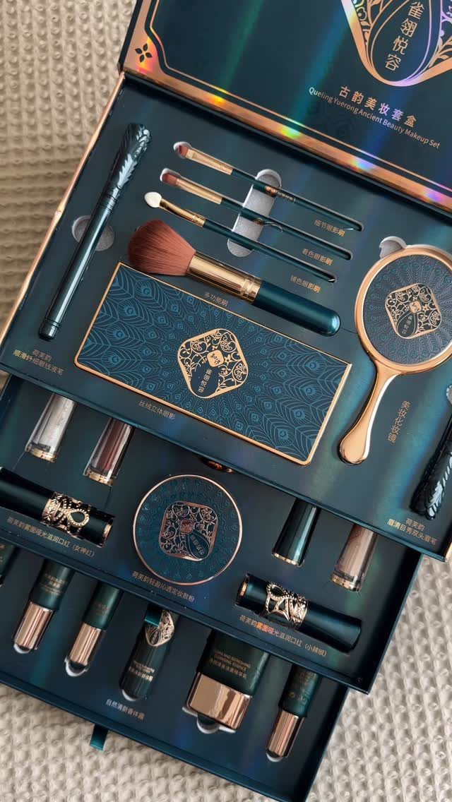 Luxury teal and gold makeup set with brushes, mirror, and cosmetics in a box.
