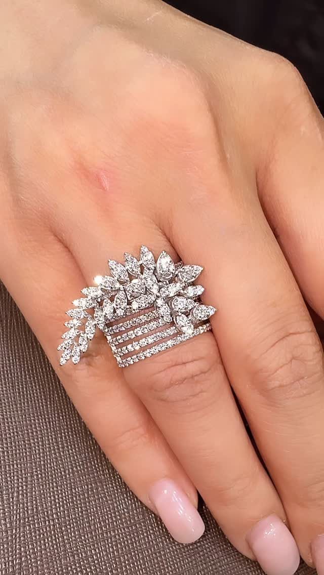 Ornate diamond ring with a fan design on a woman's finger