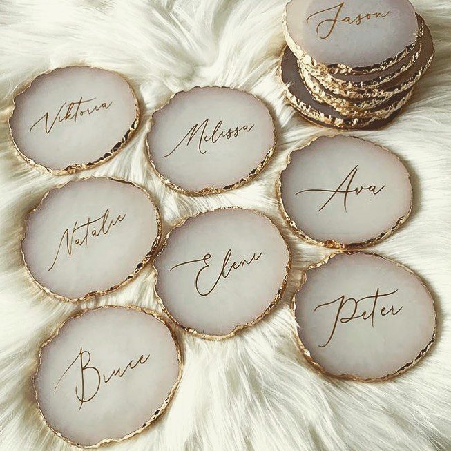 White agate coasters with gold edges and personalized names on white faux fur