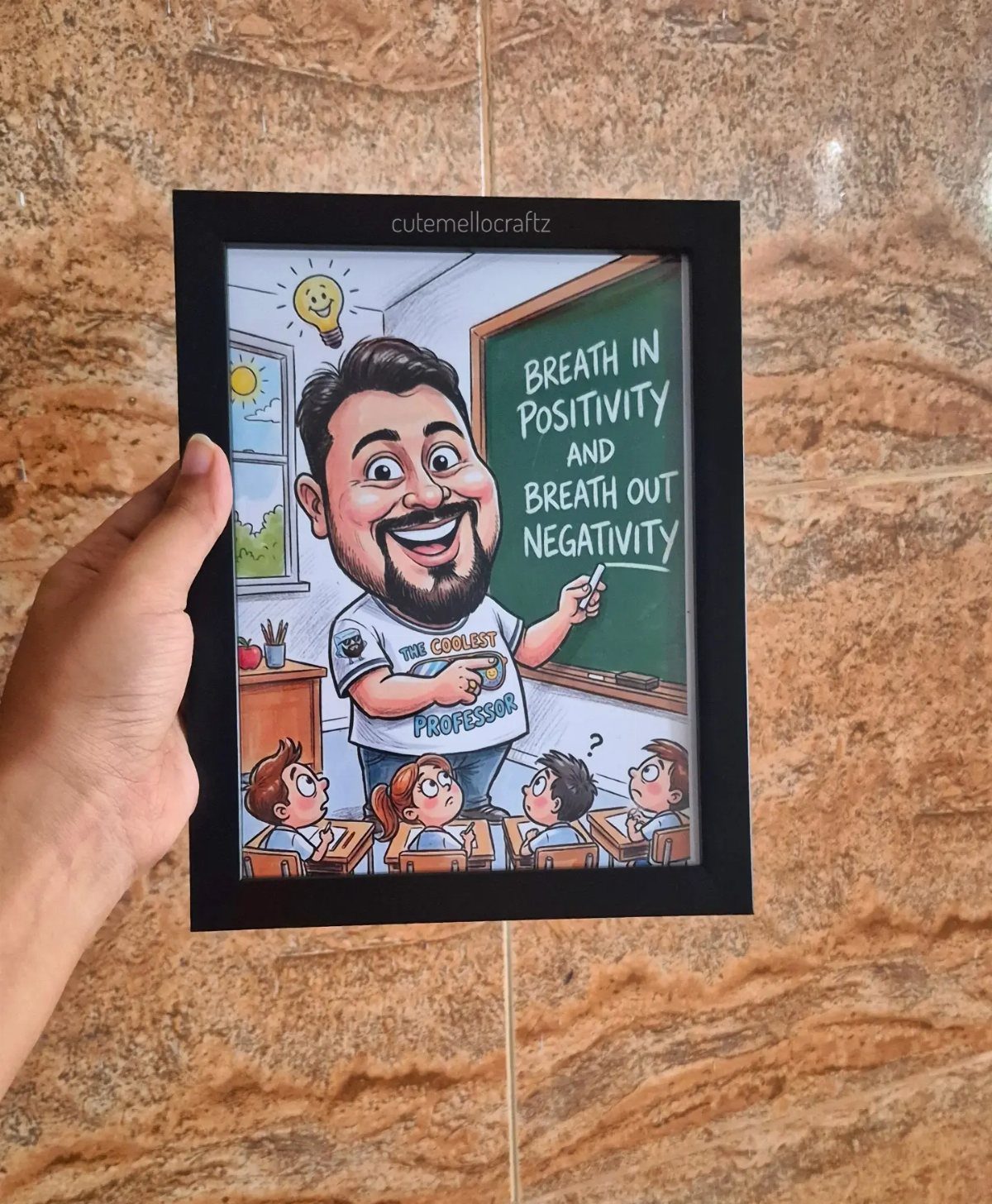 Framed caricature of a male teacher in a classroom with a positive quote.