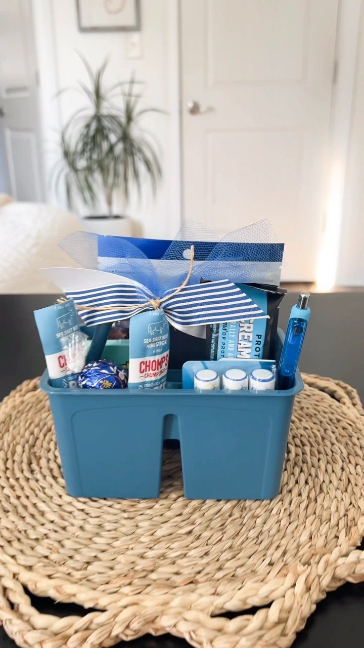 Blue snack gift basket with beef sticks and candy tied with a ribbon.