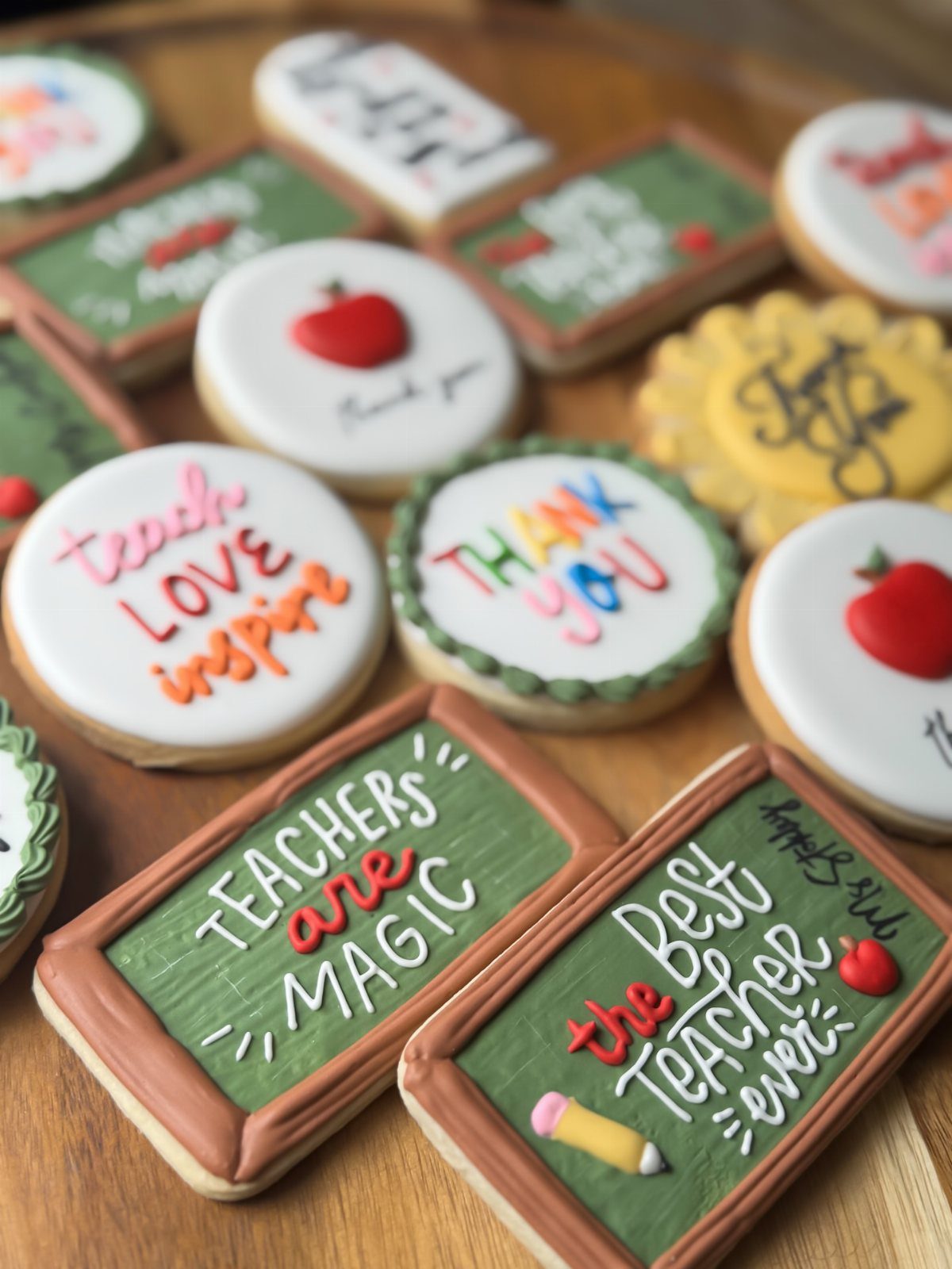 Decorated sugar cookies shaped like chalkboards and apples for teacher appreciation gifts.