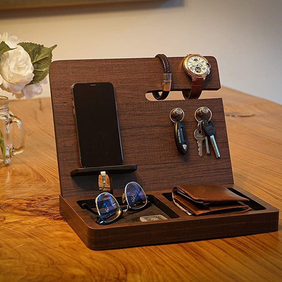 Wooden nightstand docking station holding a phone, watches, keys, sunglasses, and leather wallet.