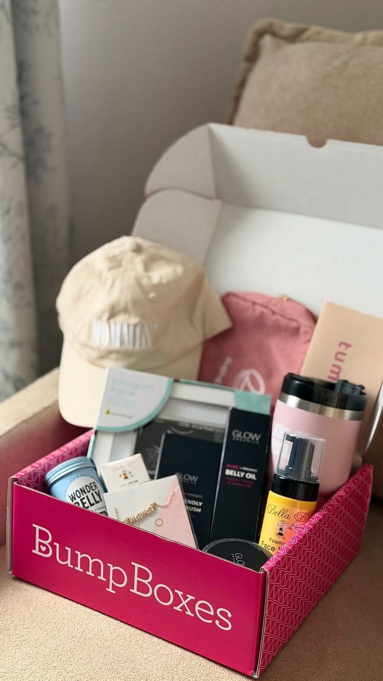 BumpBoxes gift box containing a beige cap, belly oil, and pink tumbler.