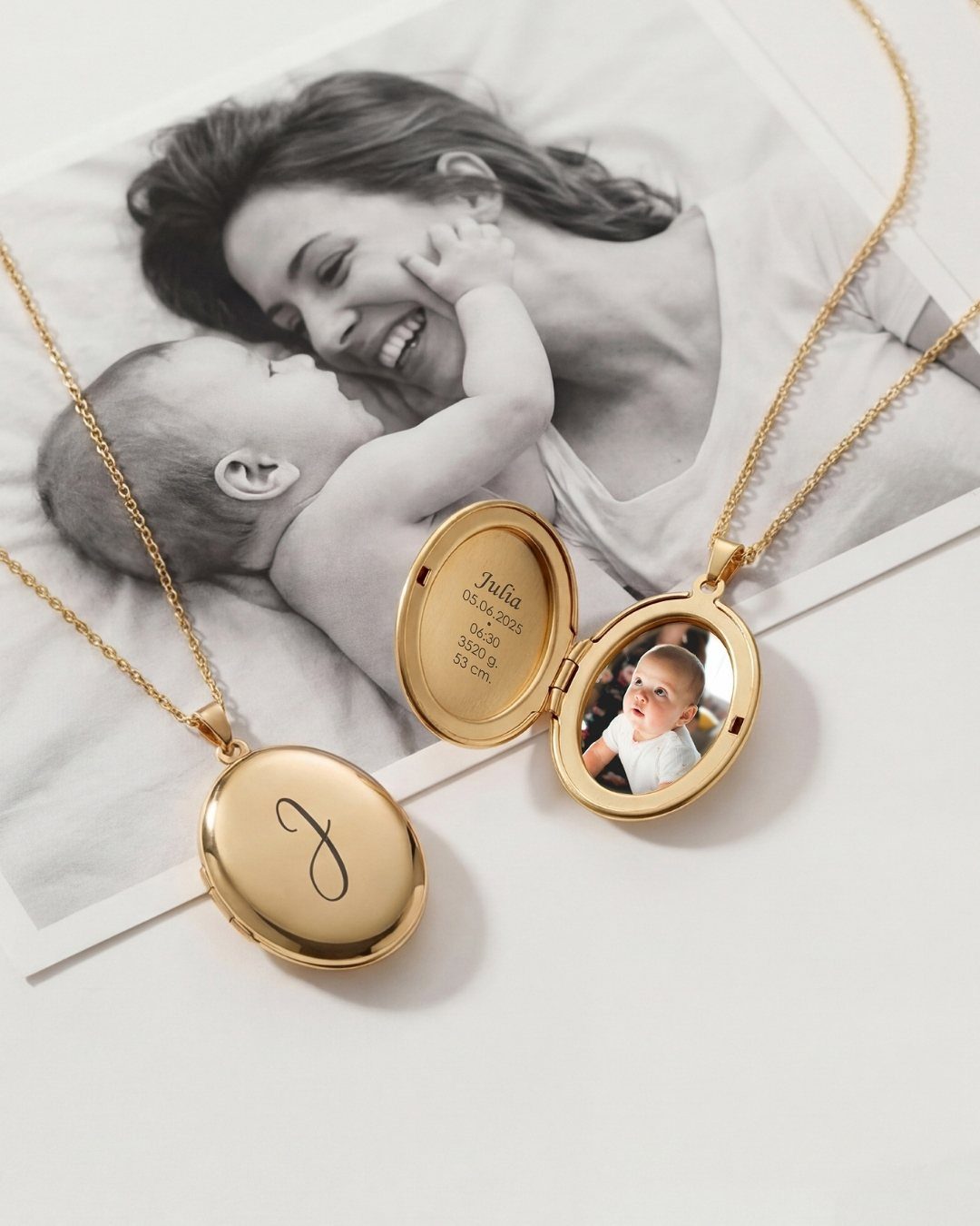 Gold oval locket necklaces resting on a black and white photo of a mother.