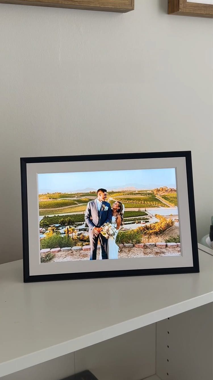Framed wedding photo of a couple in a vineyard on a white table