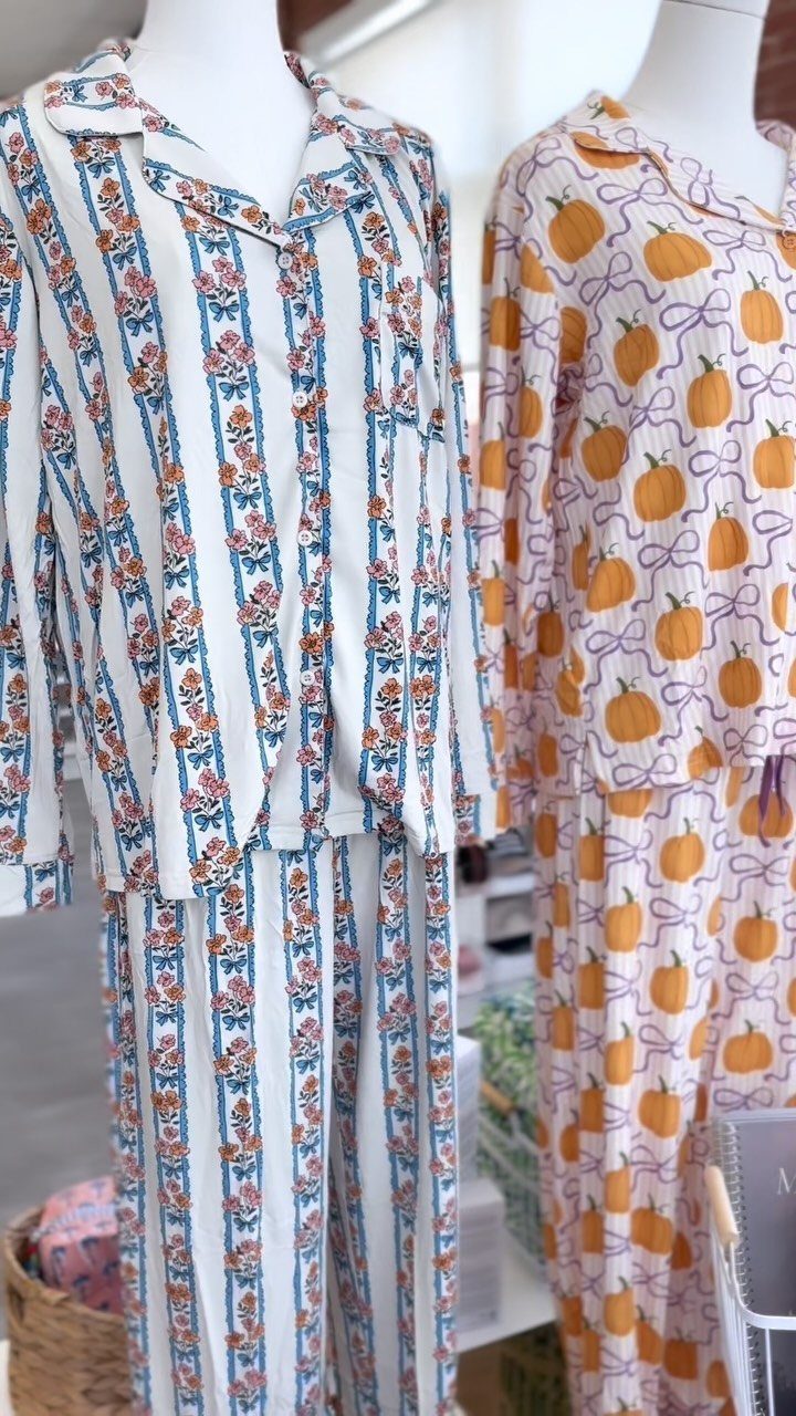 Two pajama sets on mannequins, one with floral stripes and one with pumpkins.