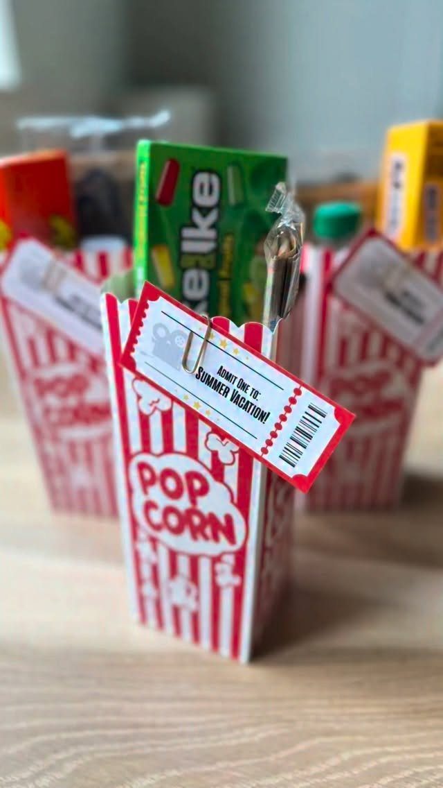 Popcorn boxes filled with movie candies and a summer vacation ticket on wood.