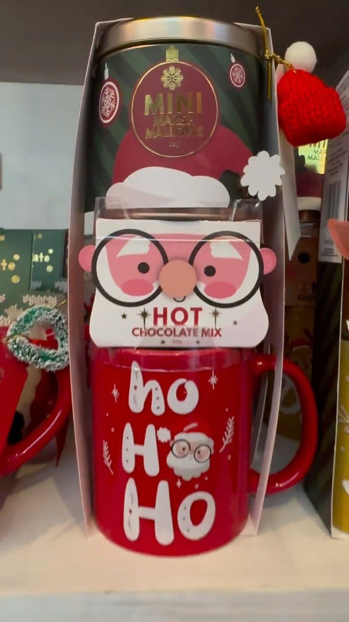 Red holiday mug containing hot chocolate mix and a canister in a gift carrier.