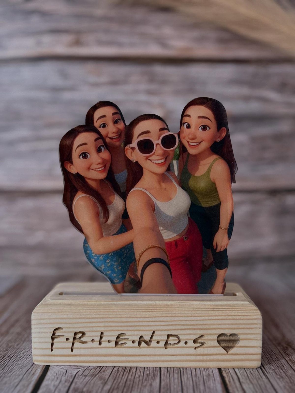 Custom acrylic standee of four cartoon friends on a wooden base engraved with FRIENDS