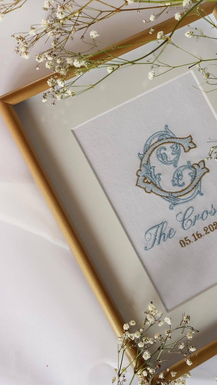Embroidered blue and gold monogram letter C in a gold frame with flowers