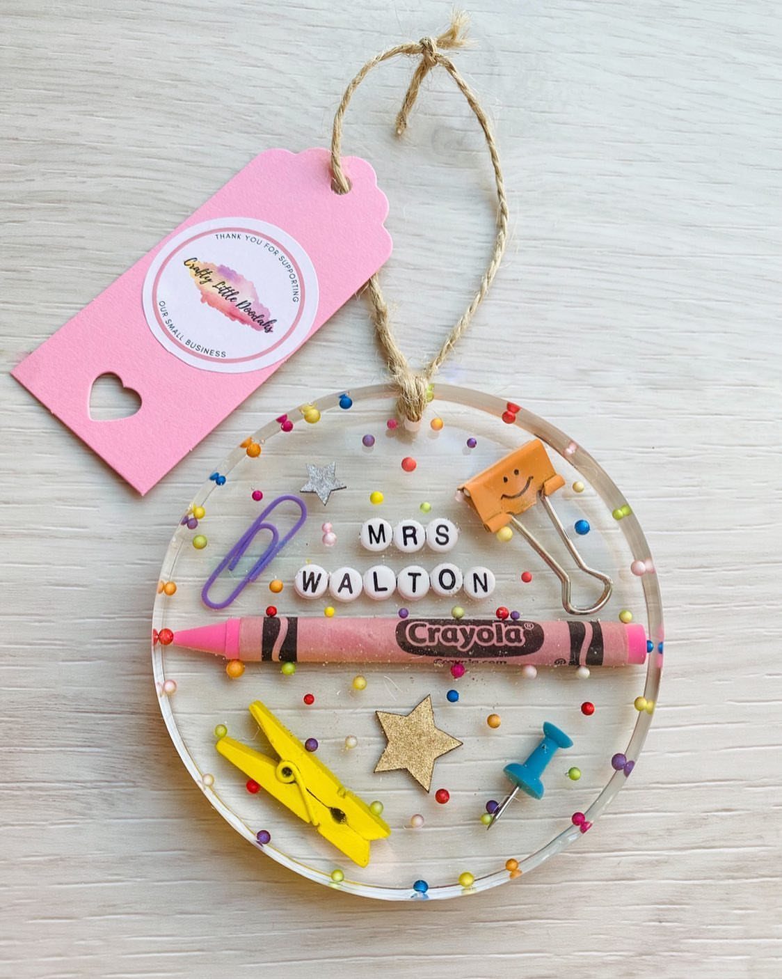 Clear acrylic ornament with school supplies and name beads for a teacher gift.