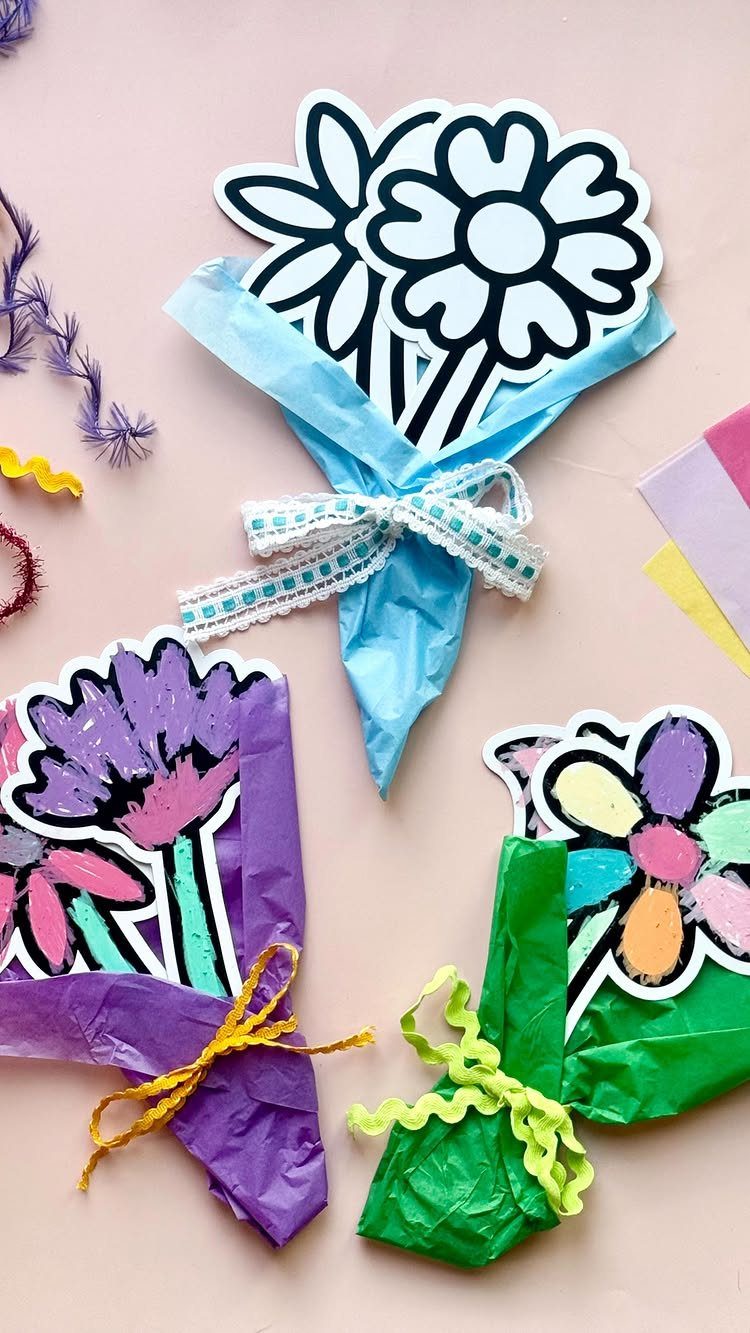 Handmade paper flower bouquets wrapped in colorful tissue paper on a pink background