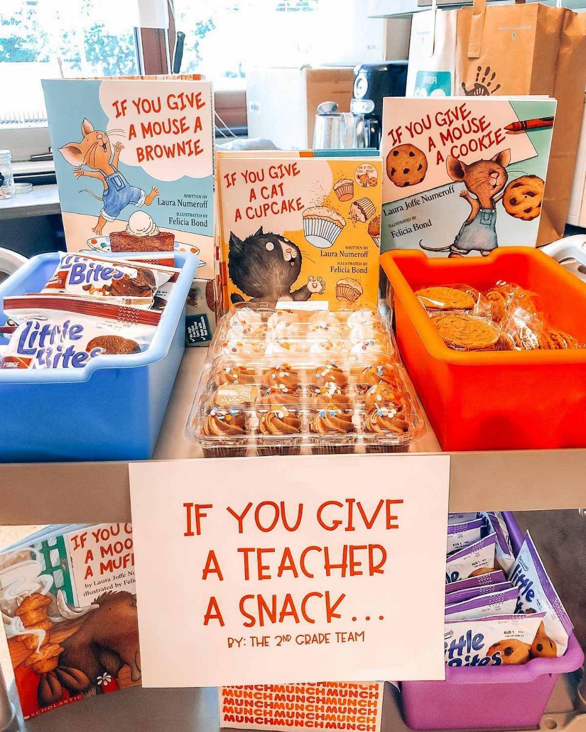 Snack basket display with cookies, muffins, children's books, and a teacher appreciation sign.