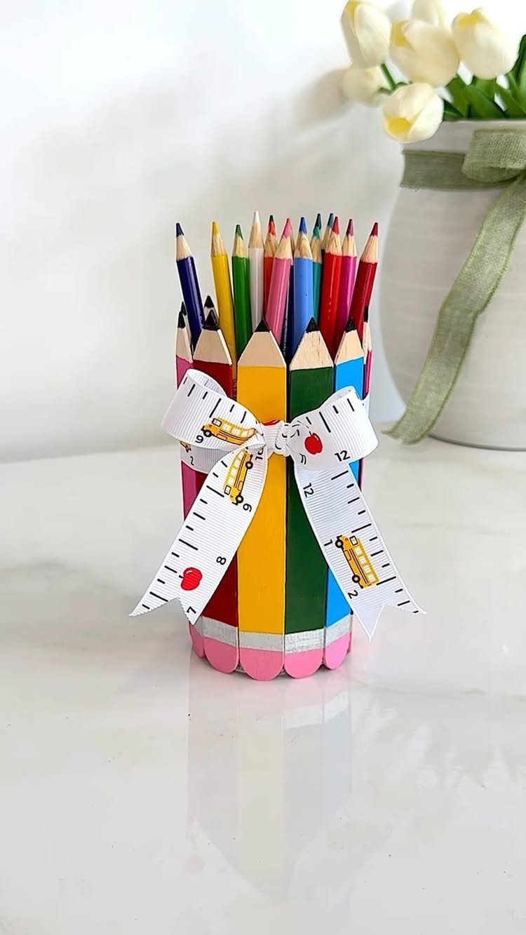 Colorful pencil holder made of wooden pencils tied with a school-themed ribbon.